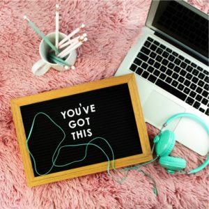 Laptop with headphones and pencils and encouraging note