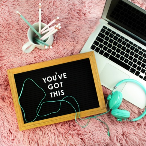 Laptop with headphones and pencils and encouraging note