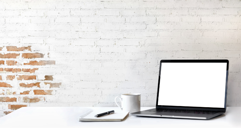 minimalist desk with laptop and notebook